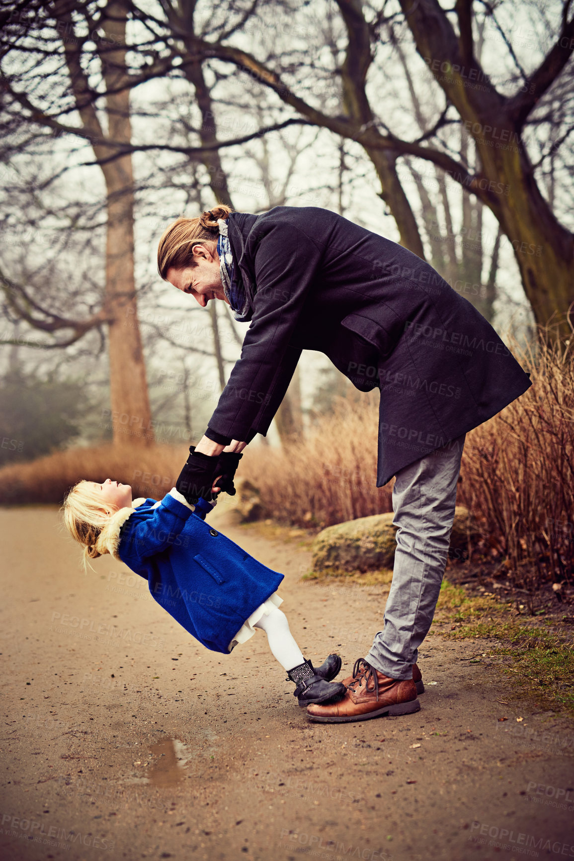 Buy stock photo Shot of a father and daughter being playful outdoors