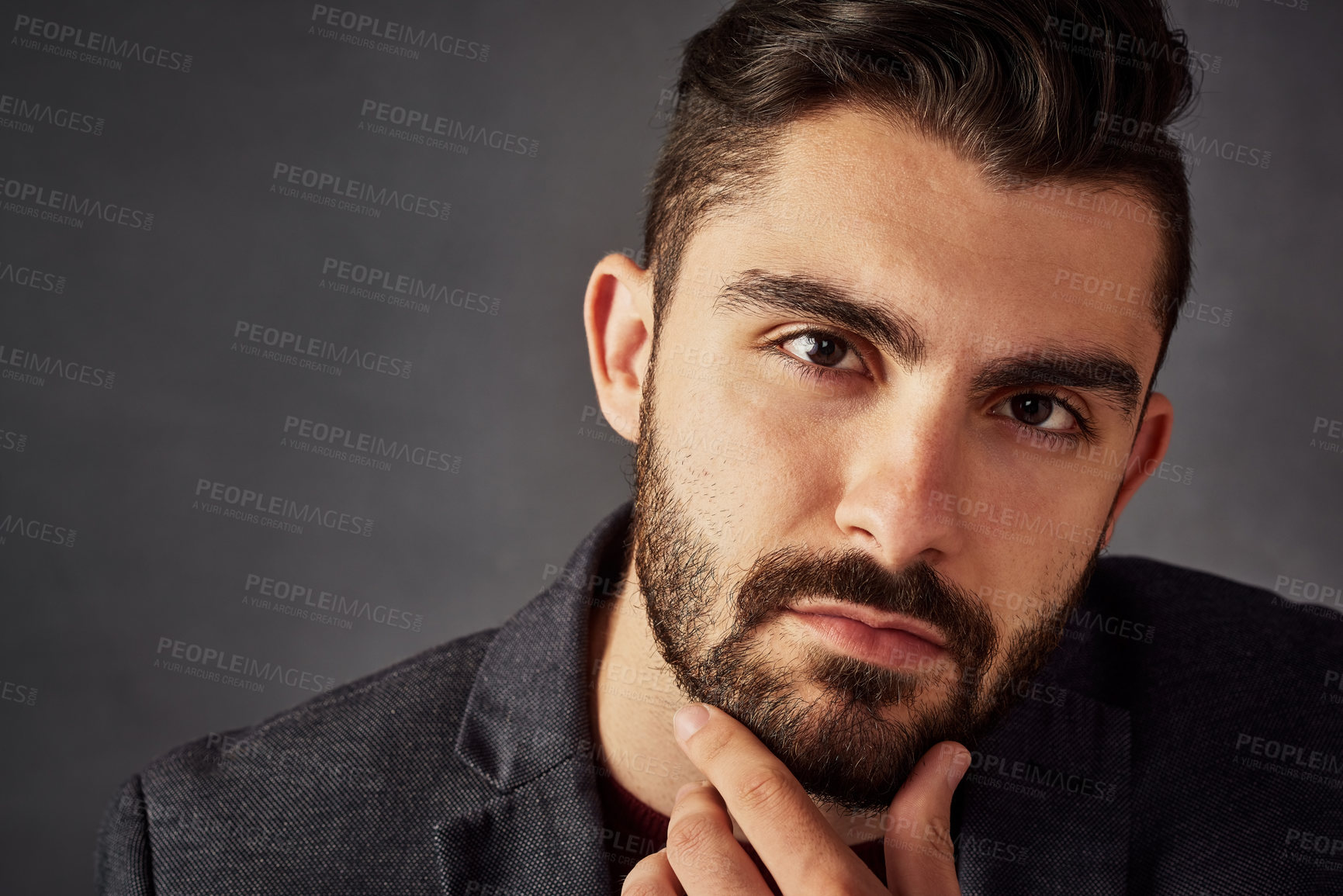 Buy stock photo Studio portrait of a handsome young man posing against a dark background