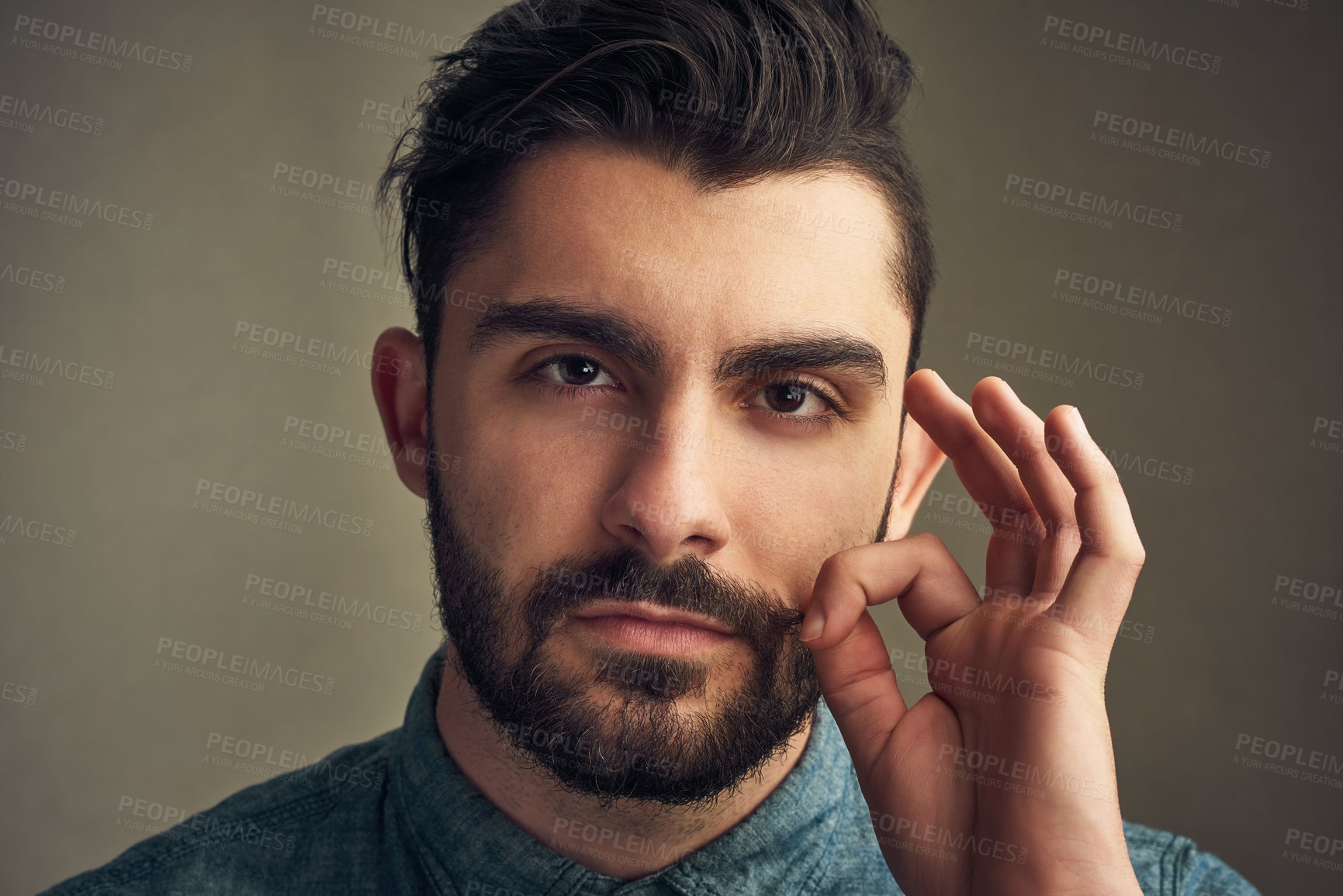 Buy stock photo Cropped shot of a young man twirling his mustache