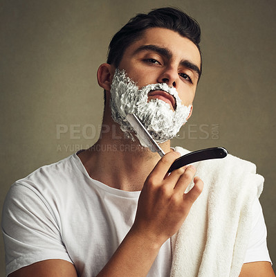 Buy stock photo Cropped shot of a handsome young man shaving with a straight razor