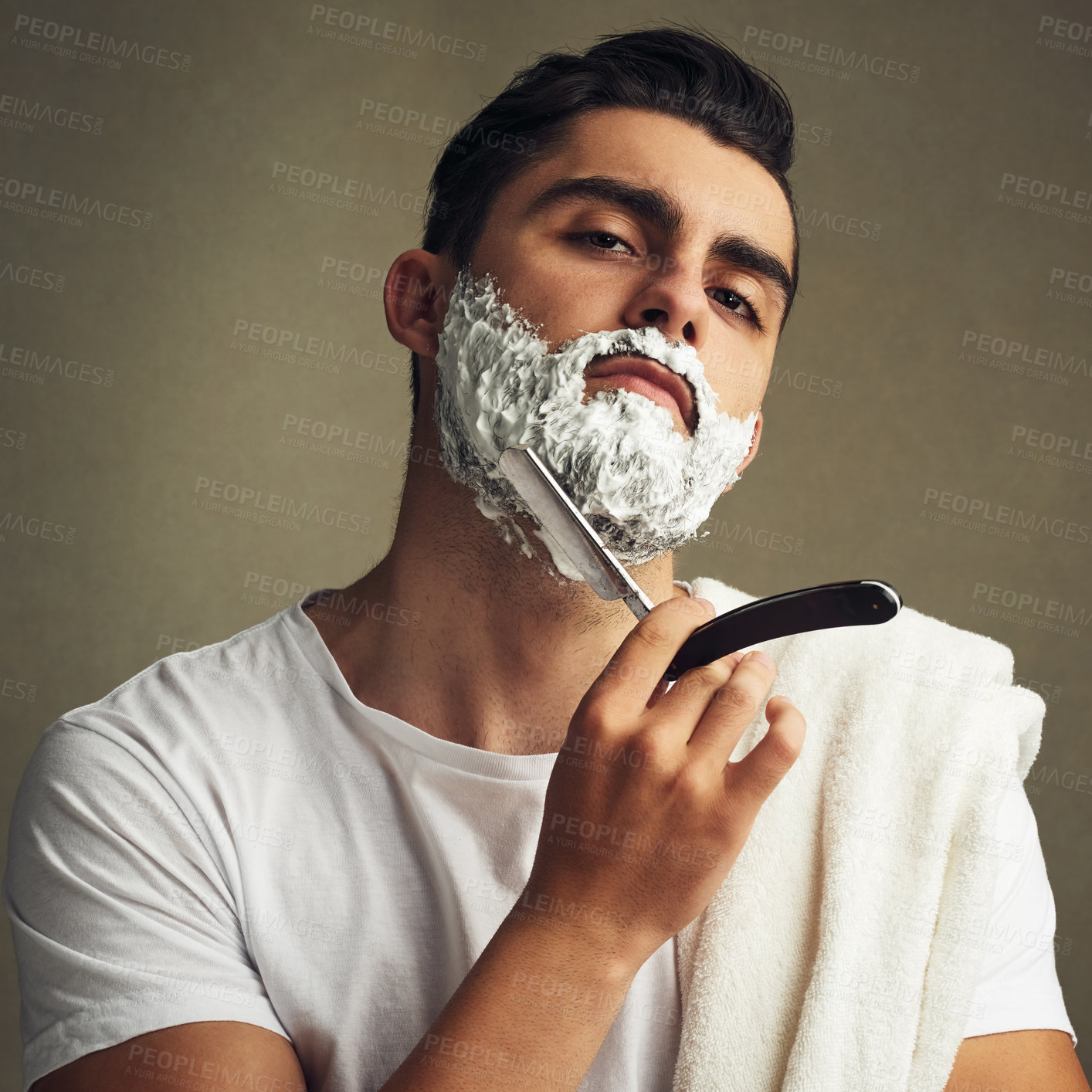 Buy stock photo Cropped shot of a handsome young man shaving with a straight razor