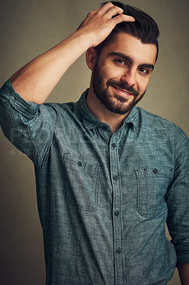 Buy stock photo Studio shot of a handsome young man posing with his hand in hair