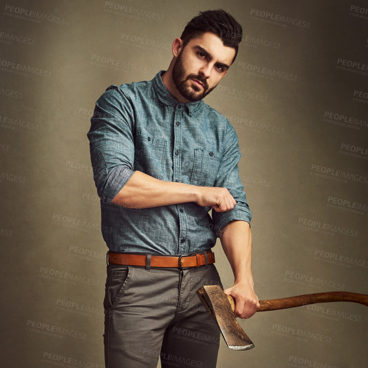 Buy stock photo Studio shot of a young man posing with an axe against a green background