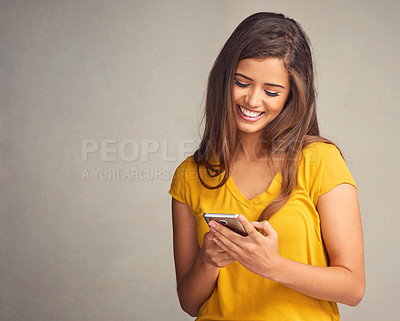 Buy stock photo Woman, smile and notification with smartphone in studio background for social media, networking and online dating. Female person, happy and satisfied with good news, text message and mockup space