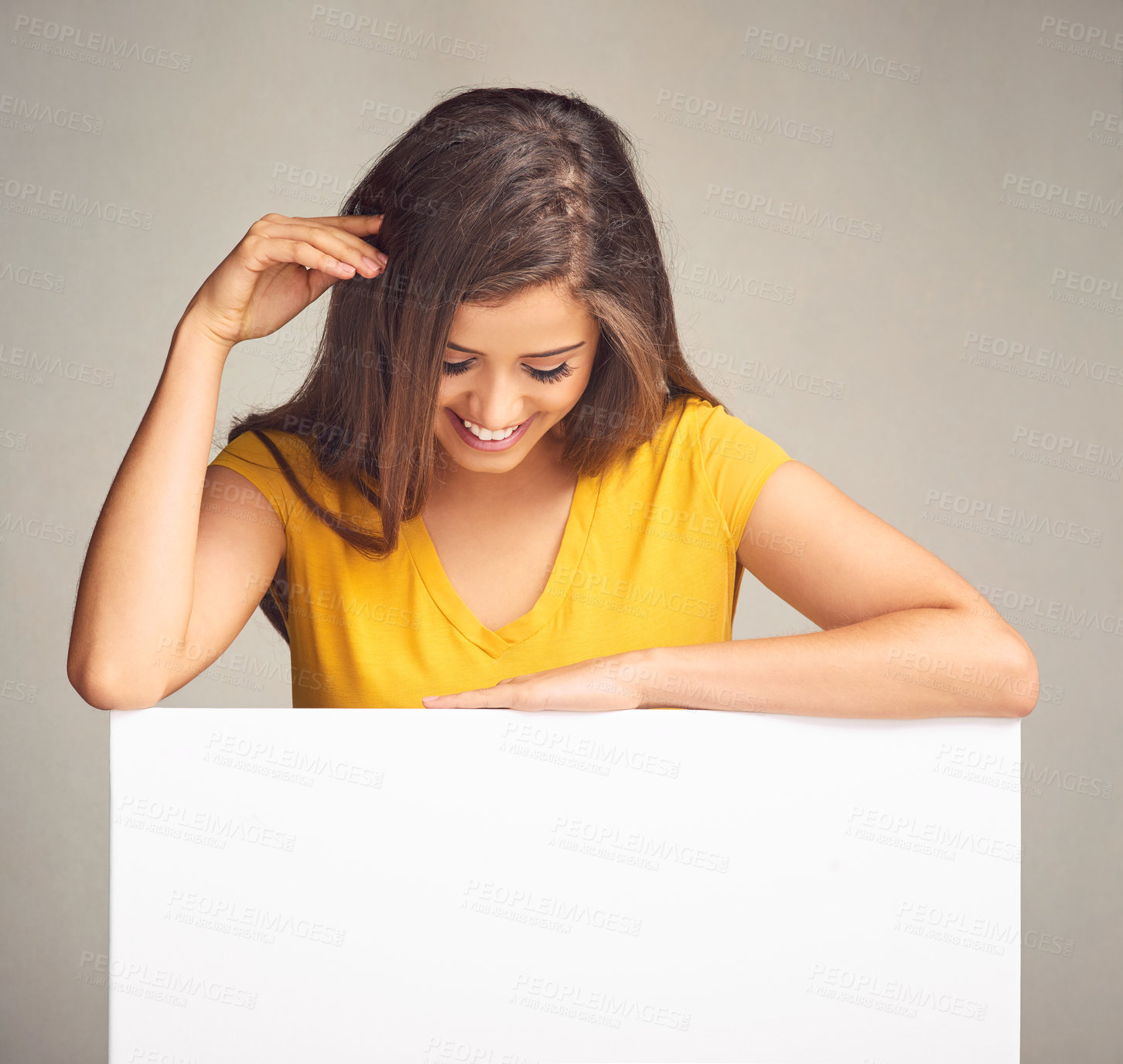 Buy stock photo Relax, smile and woman with poster in studio for billboard, design and advertising of information. Happy, person and paper banner with mockup space for marketing, sign or promotion on gray background