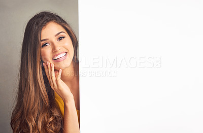 Buy stock photo Happy, woman and portrait with placard in studio for poster, marketing and billboard information. Person, smile and mockup space on paper banner for advertising, promotion and sign on gray background