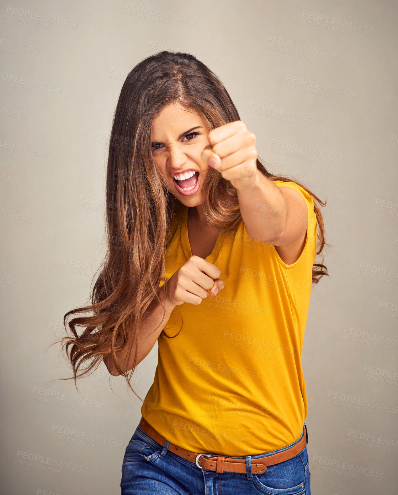 Buy stock photo Portrait, angry woman and fist for fight, power and conflict or protest violence isolated on studio background. Face, punch or girl with confidence, strong or scream for boxing attack or self defense