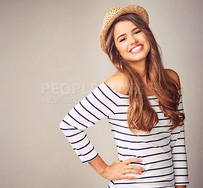 Buy stock photo Studio portrait of an attractive and happy young woman posing against a gray background