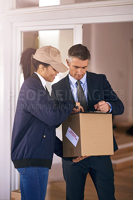 Buy stock photo Shot of a mature well dressed man receiving a package and signing it in his home