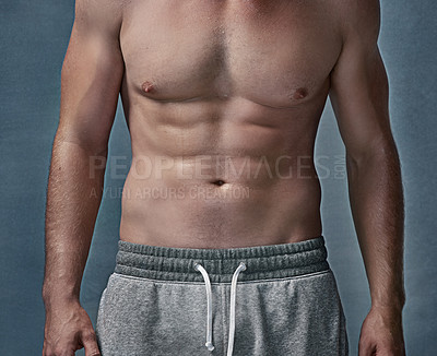 Buy stock photo Cropped shot of an unidentifiable young man's muscular abdomen in studio