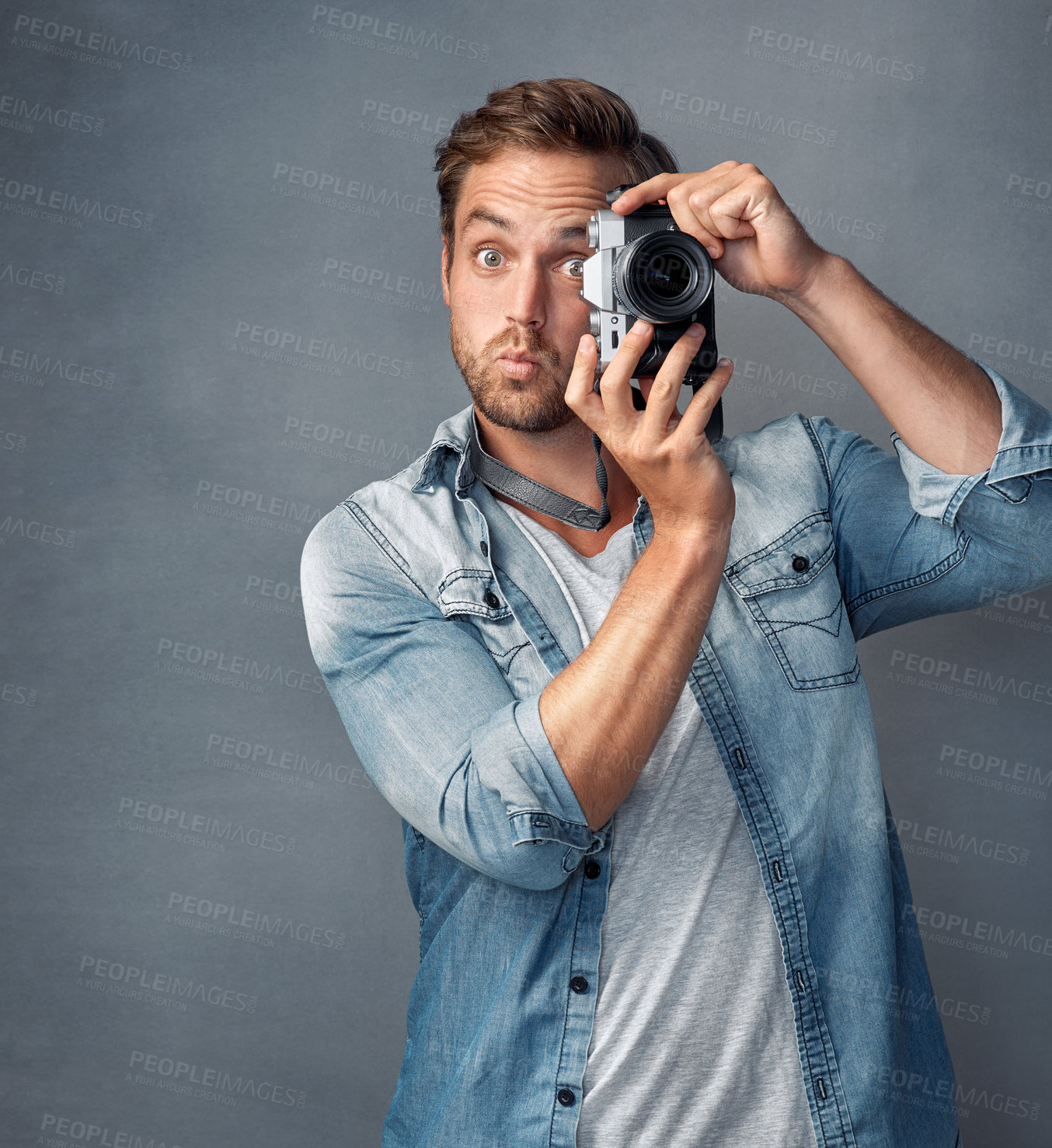 Buy stock photo Surprise, photography and portrait of man in studio for digital media, technology or photoshoot. Shocked, photographer and eye with equipment for paparazzi, news or production or on grey background