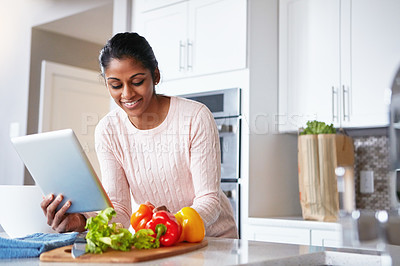 Buy stock photo Tablet, ingredients and woman in kitchen with recipe online for health, wellness and diet meal. Reading, vegetables and Indian person with digital technology for nutrition food instructions at home.