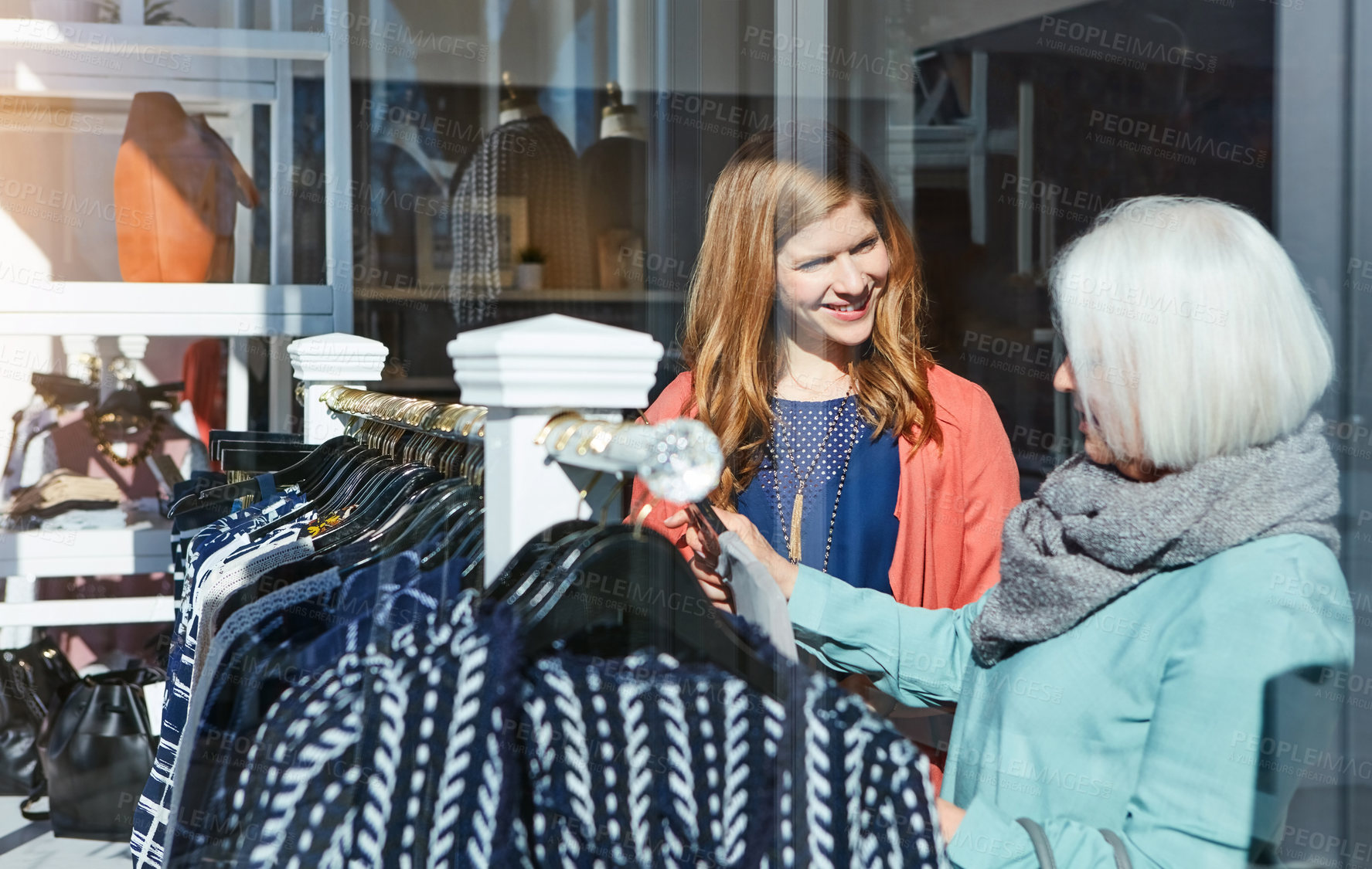 Buy stock photo Shot of a mother and daughter shopping in a clothing store