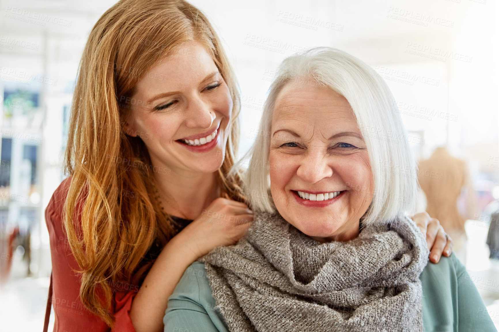 Buy stock photo Shot of a happy young woman standing behind her senior mother