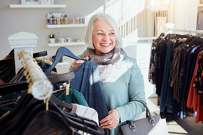 Buy stock photo Shot of a senior woman shopping in a clothing boutique