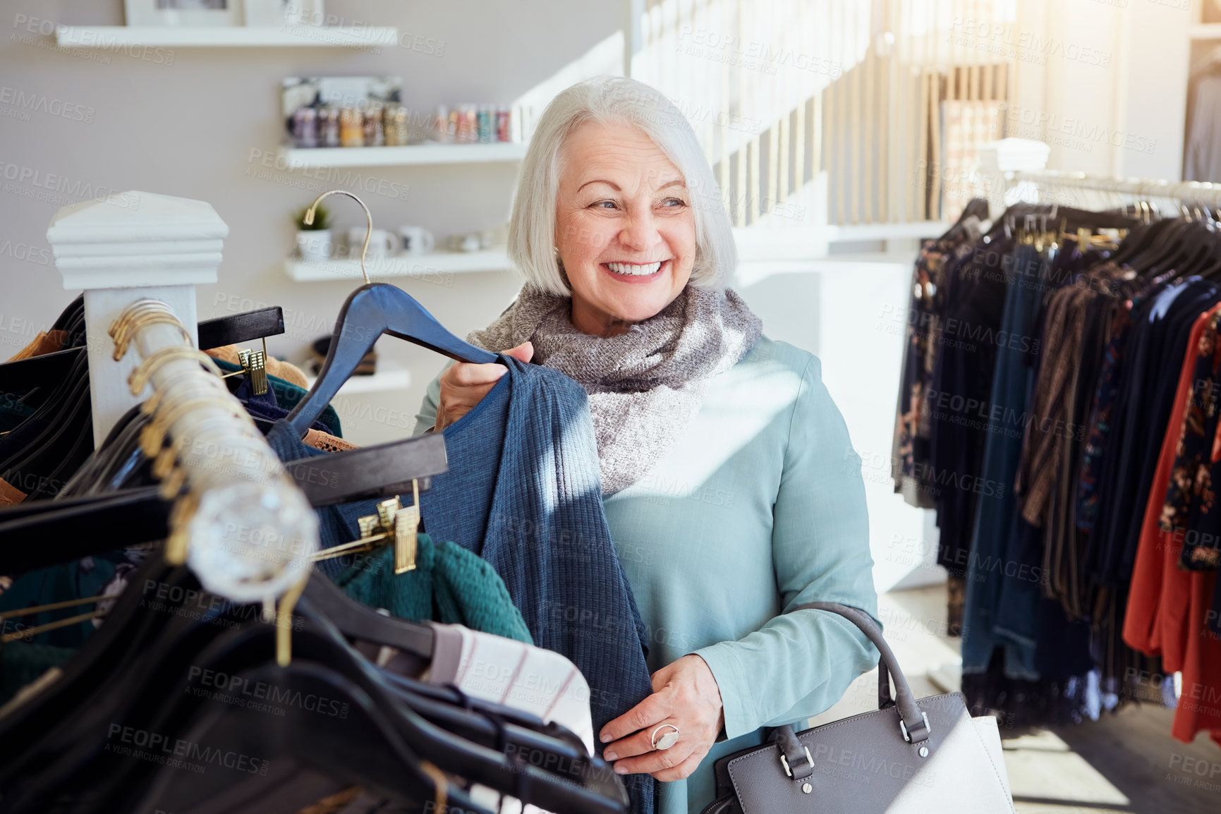 Buy stock photo Shot of a senior woman shopping in a clothing boutique