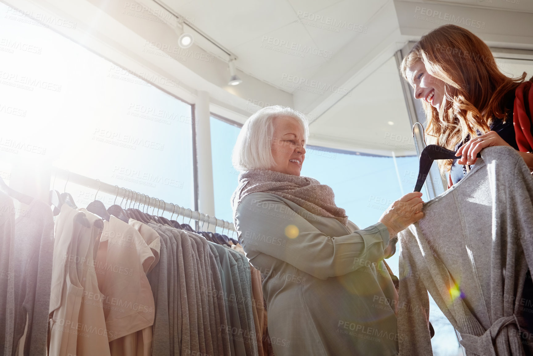 Buy stock photo Shot of a mother and daughter shopping in a clothing boutique