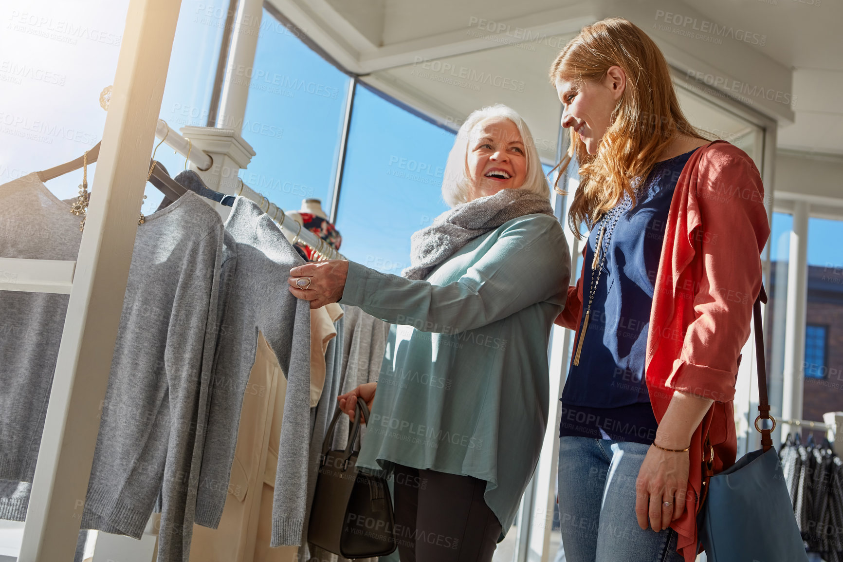 Buy stock photo Shot of a mother and daughter shopping in a clothing store