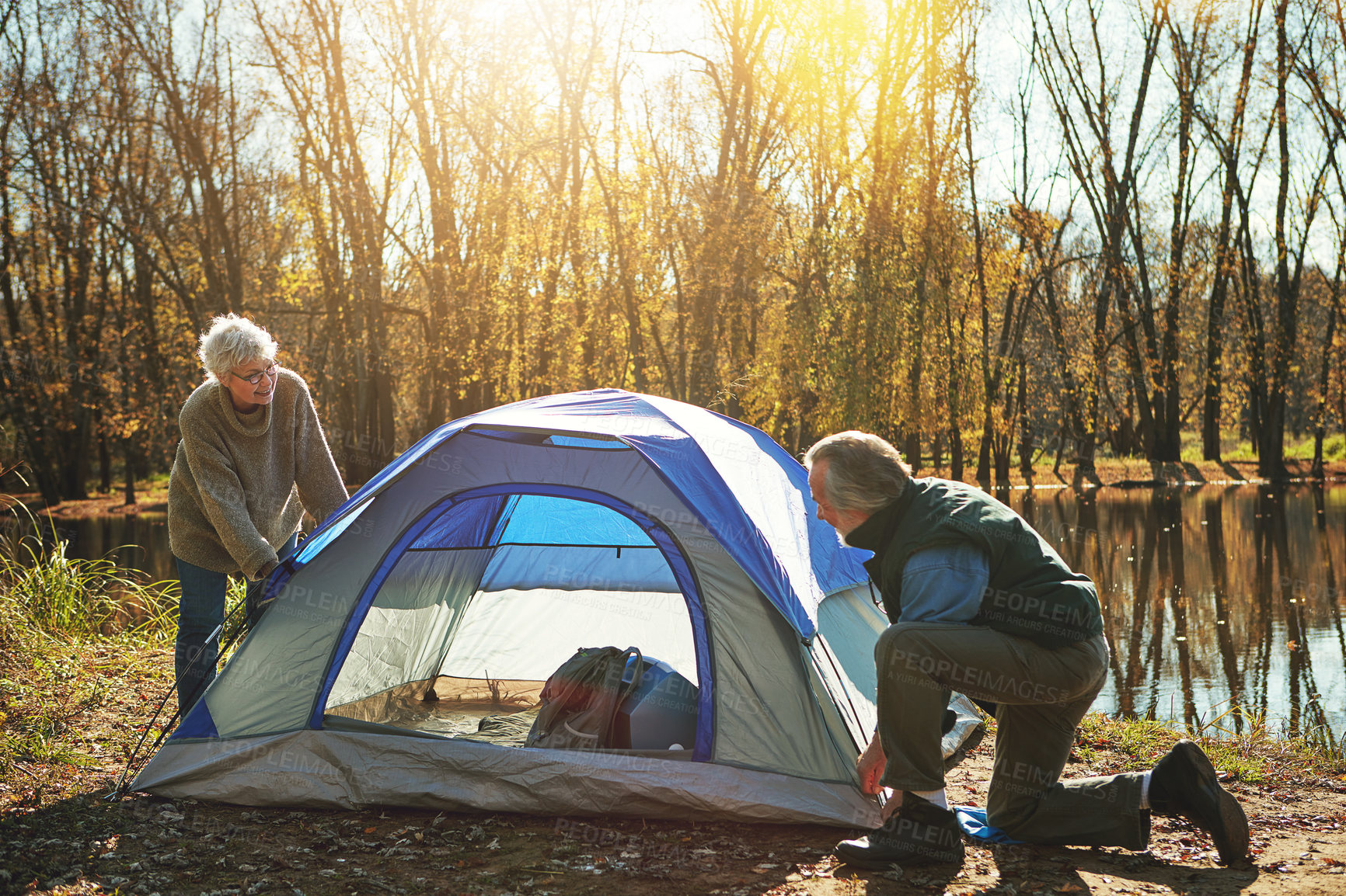 Buy stock photo Shot of a senior couple setting up a tent while camping in the wilderness