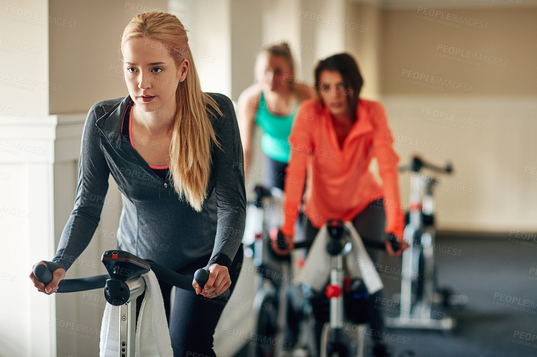 Buy stock photo People, exercise bike and gym for aerobics, training and cycling for fitness at class. Women, riding and stationary machine for workout challenge, spinning instructor and equipment for practice