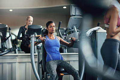 Buy stock photo Shot of a young woman working out with a chest press at a gym