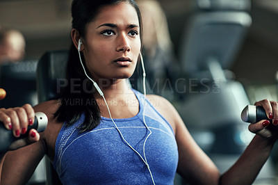 Buy stock photo Shot of a young woman working out with a chest press at a gym