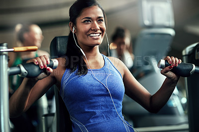 Buy stock photo Shot of a young woman working out with a chest press at a gym