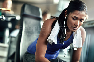 Buy stock photo Shot of a young woman taking a break from her workout at the gym