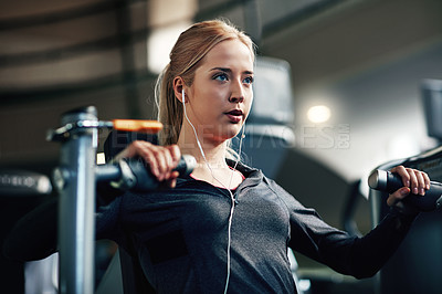 Buy stock photo Shot of a young woman working out with a chest press at a gym