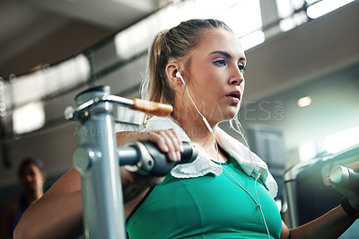 Buy stock photo Shot of a young woman working out with a chest press at a gym