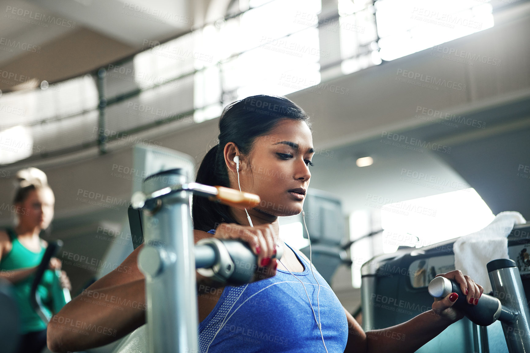 Buy stock photo Shot of a young woman working out with a chest press at a gym