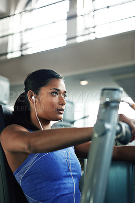 Buy stock photo Shot of a young woman working out with a chest press at a gym