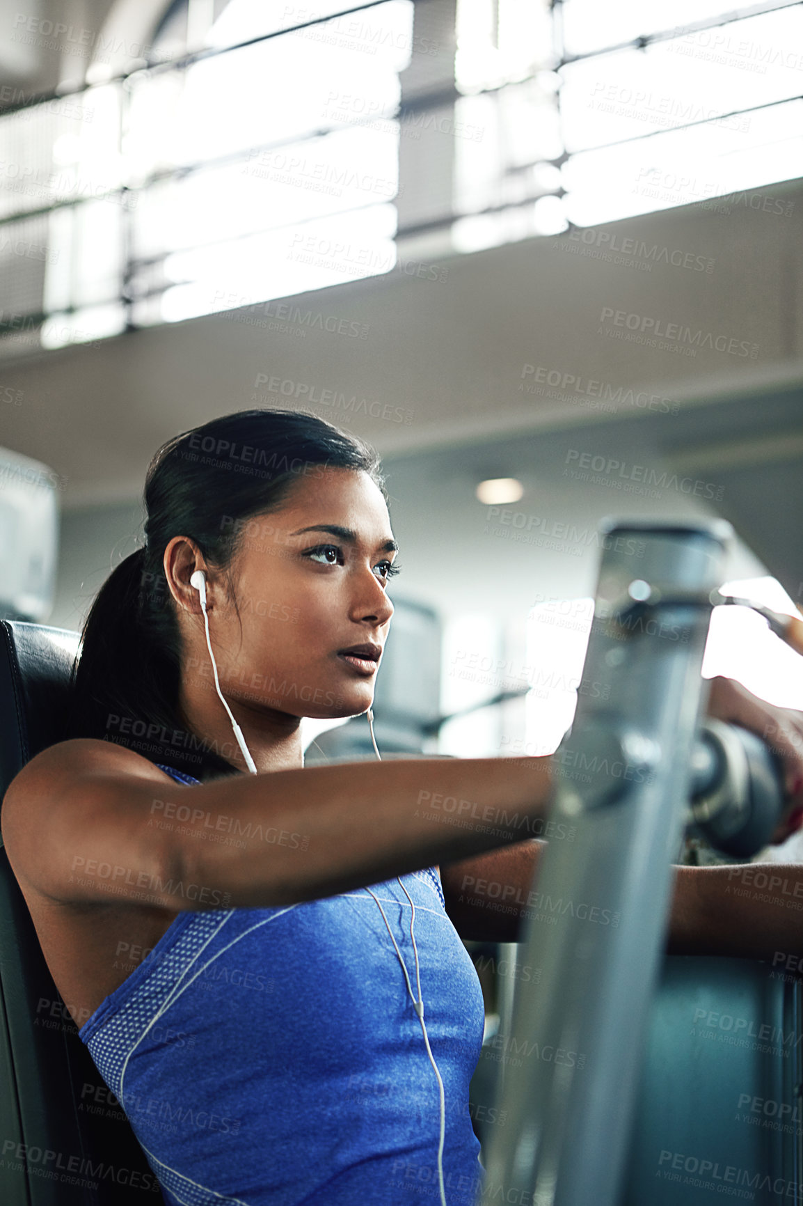 Buy stock photo Shot of a young woman working out with a chest press at a gym