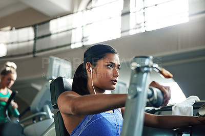 Buy stock photo Shot of a young woman working out with a chest press at a gym