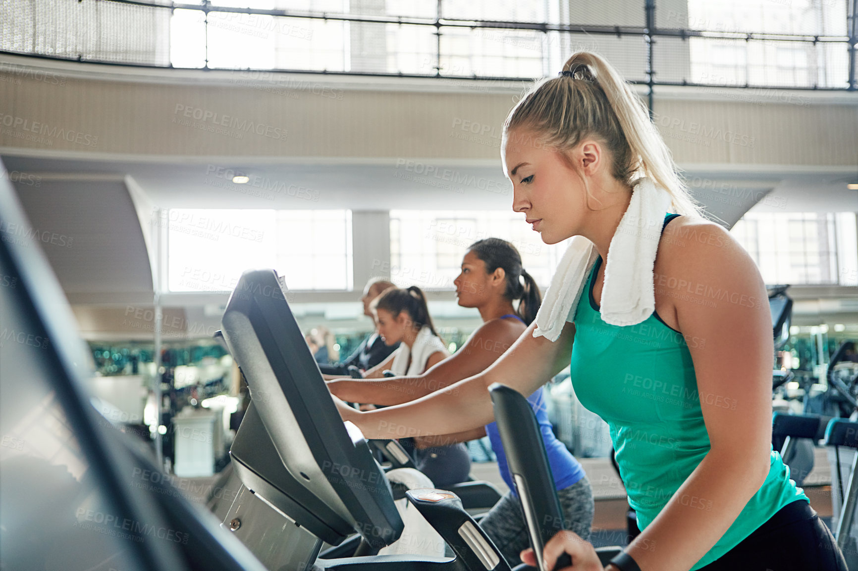 Buy stock photo Shot of a young woman working out with a machine at a gym