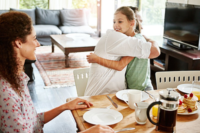 Buy stock photo Shot of a little girl hugging her father at the breakfast table