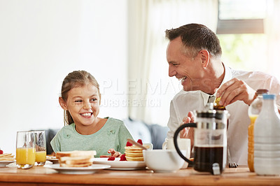 Buy stock photo Shot of a father and his little daughter having breakfast together at home