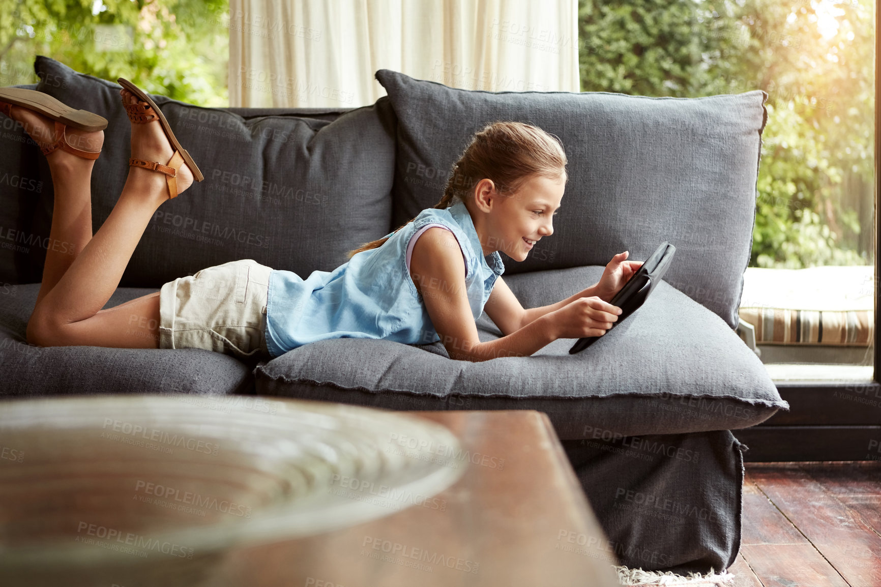 Buy stock photo Shot of a little girl using a digital tablet at home