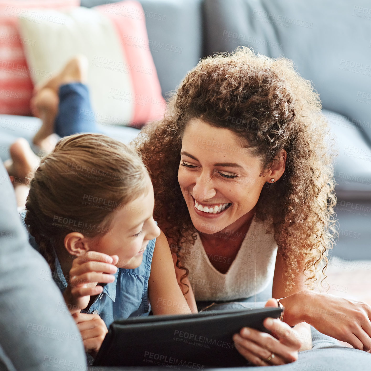 Buy stock photo Shot of a mother and her little daughter using a digital tablet together at home