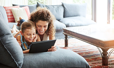 Buy stock photo Shot of a mother and her little daughter using a digital tablet together at home