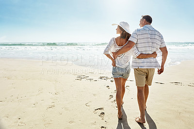 Buy stock photo Shot of a mature couple walking along the beach