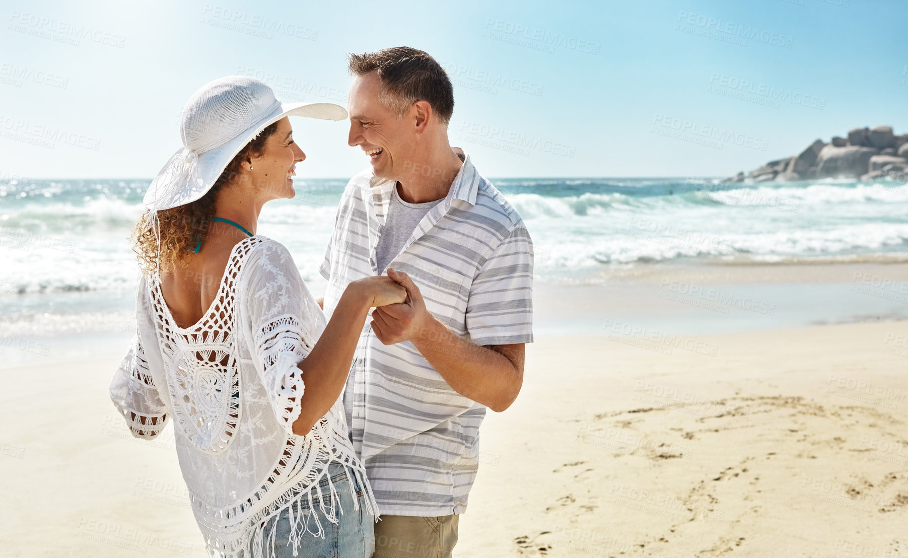 Buy stock photo Shot of a mature couple enjoying some quality time together at the beach