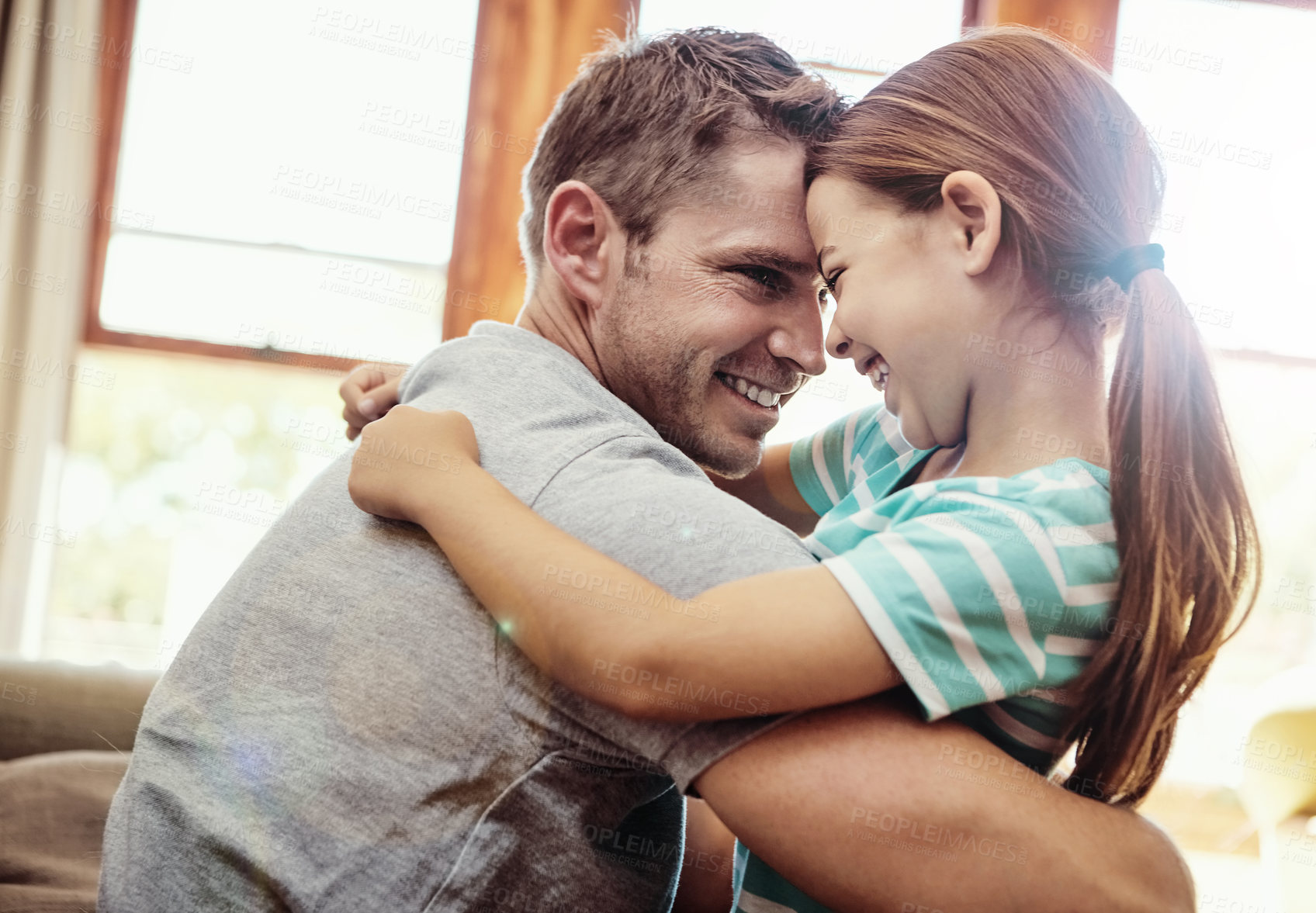 Buy stock photo Shot of a little girl hugging her father at home