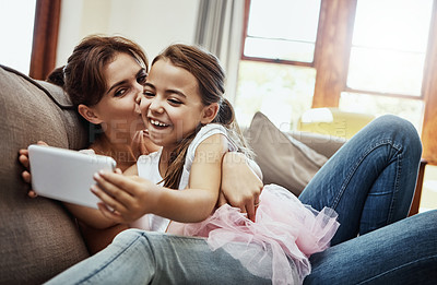 Buy stock photo Shot of a little girl taking a selfie with her mother at home