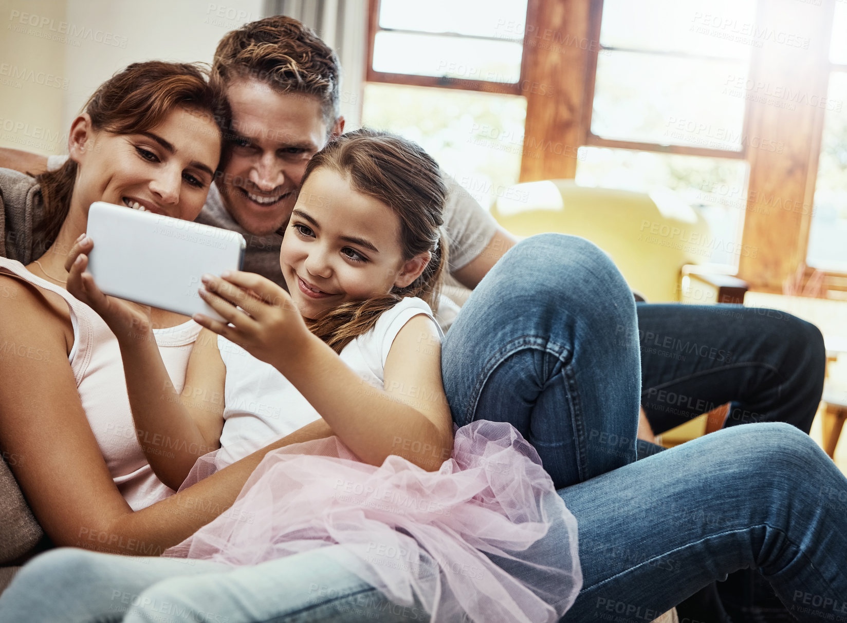 Buy stock photo Shot of a little girl taking a selfie with her parents at home