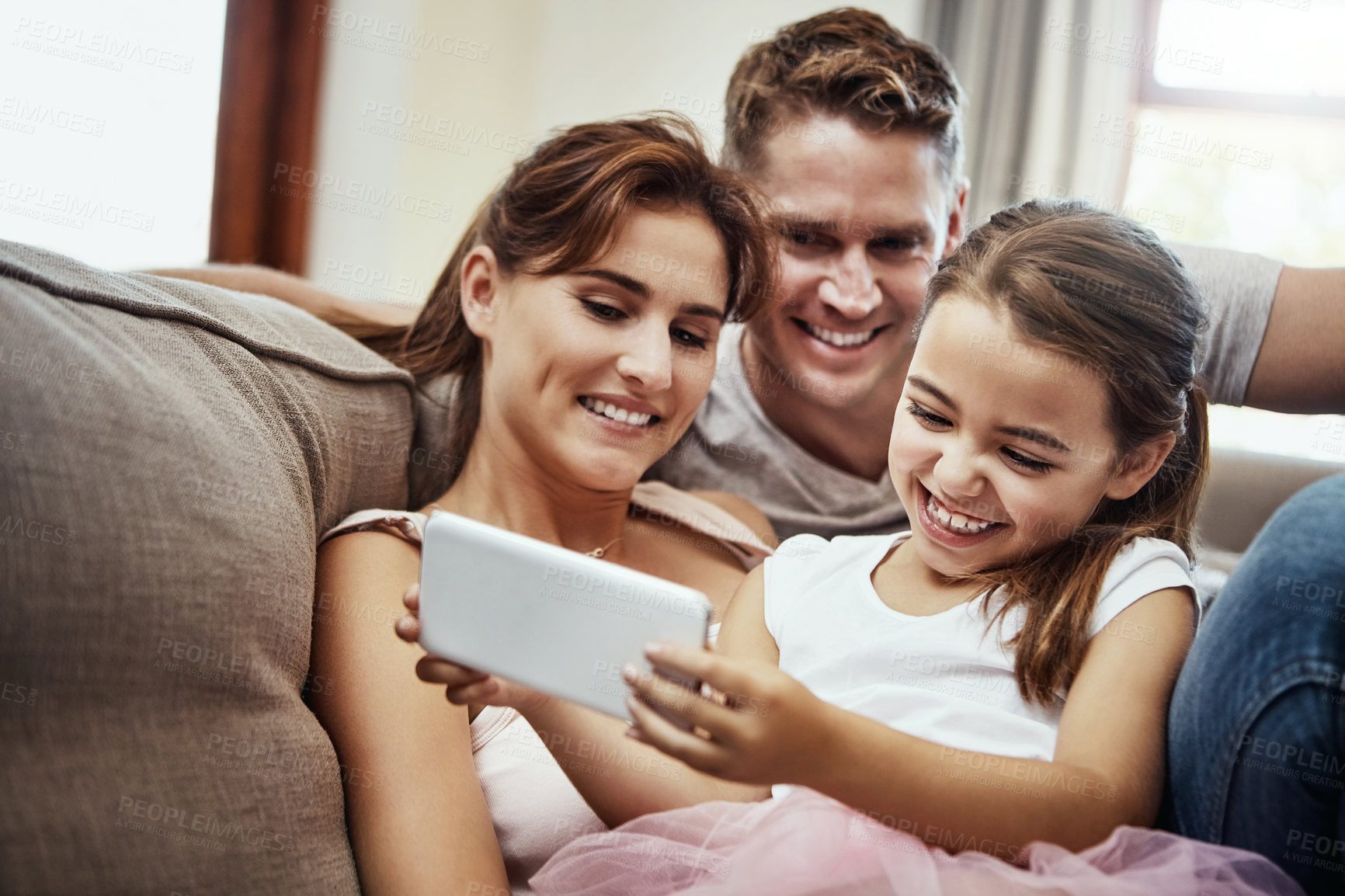 Buy stock photo Shot of a little girl taking a selfie with her parents at home