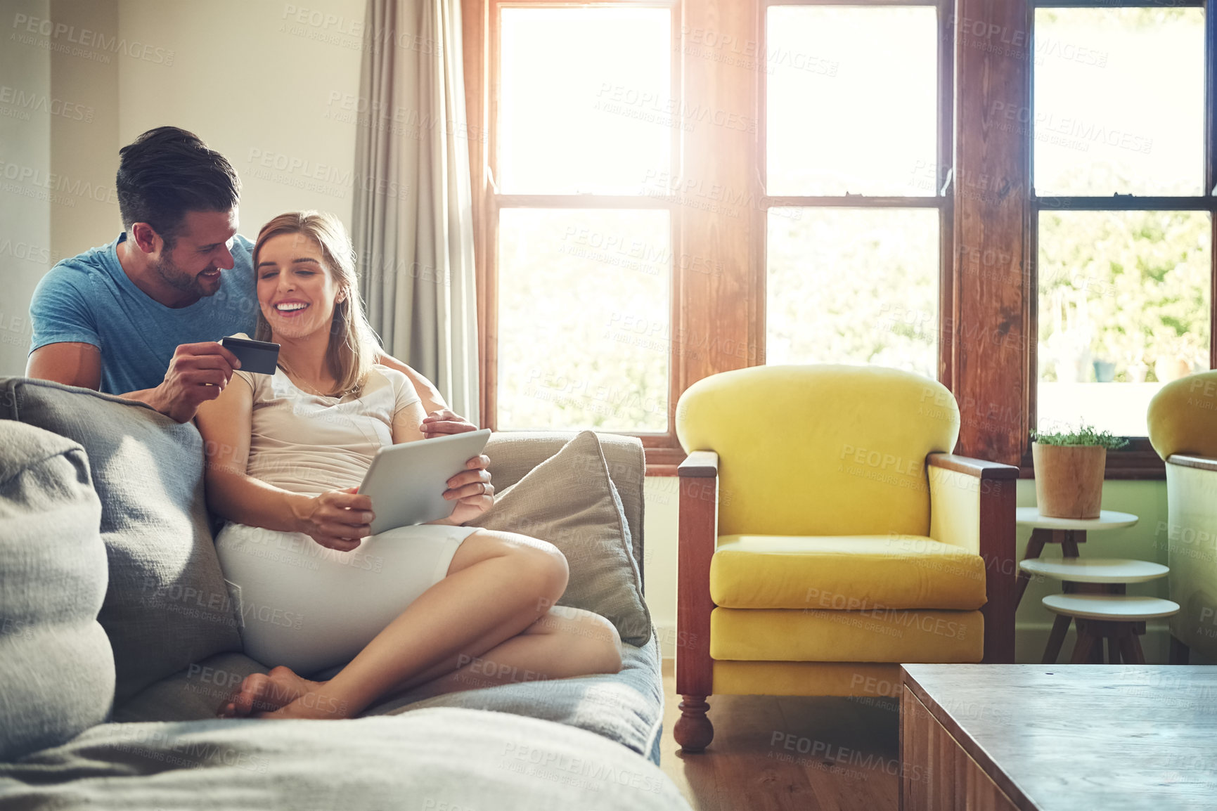 Buy stock photo Shot of a young couple doing some online shopping on a digital tablet