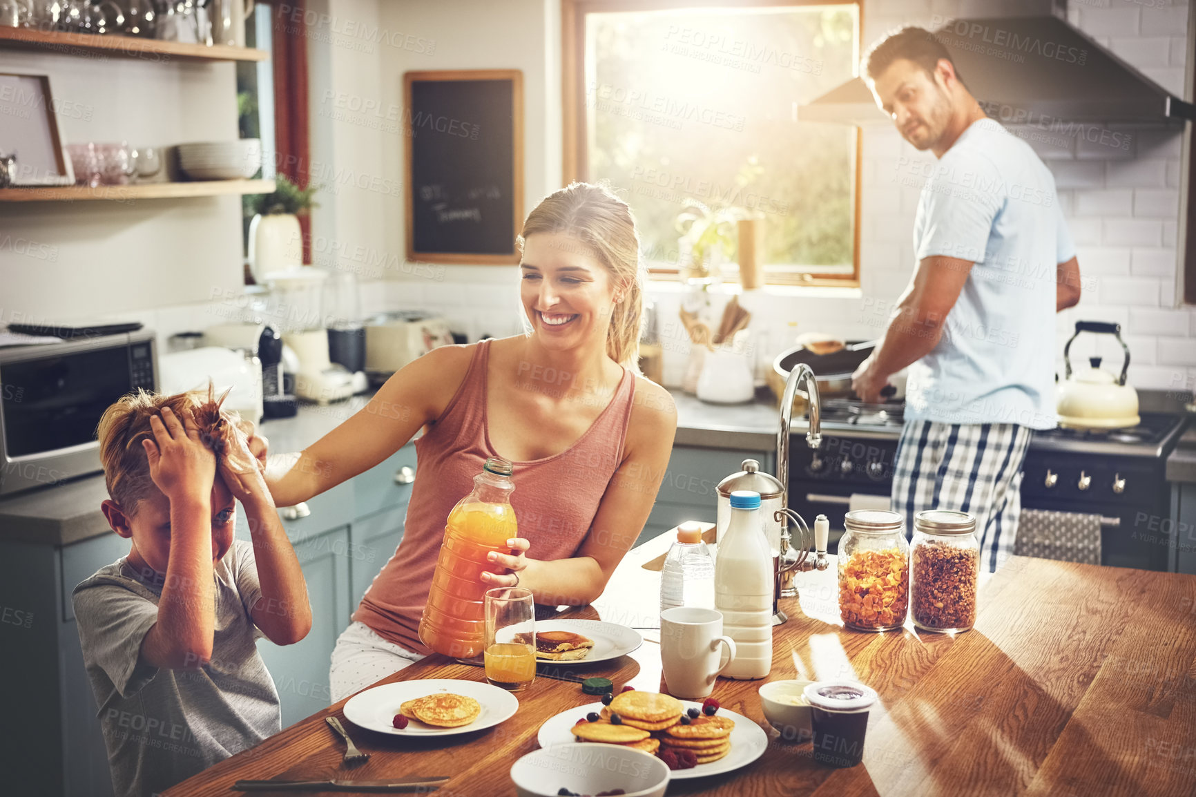 Buy stock photo Cropped shot of a little boy eating breakfast with his parents