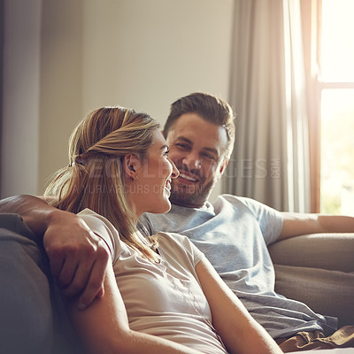 Buy stock photo Shot of an affectionate young couple relaxing on the sofa at home