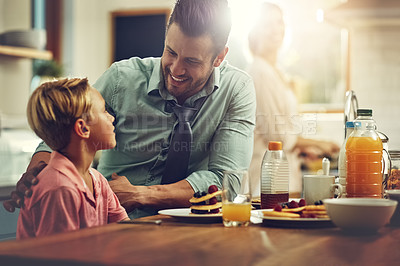 Buy stock photo Shot of a man sitting with his son while he's having breakfast